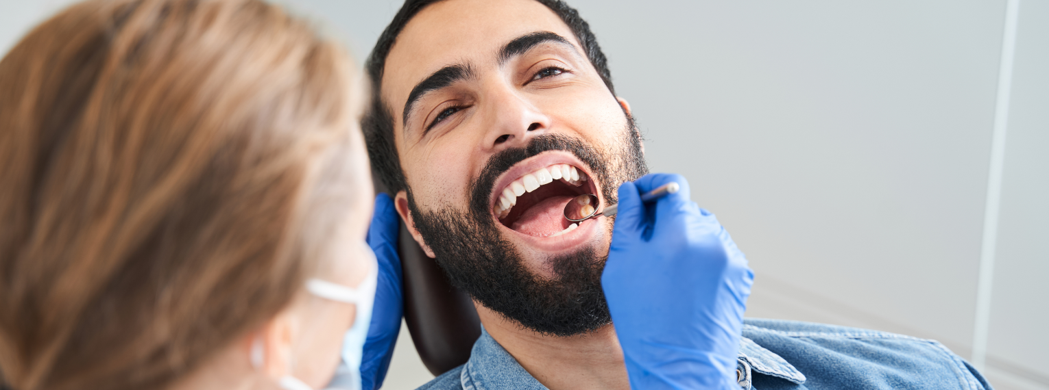 Ein Patient wird von einer Zahnärztin untersucht.