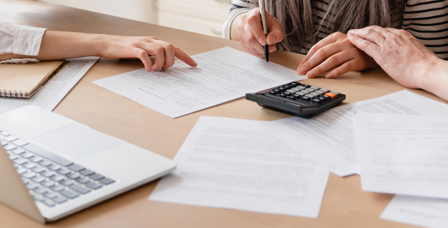 Mehrere Personen schauen sich die Konditionen eines Zahnzusatzversicherungsvertrag genauer an.