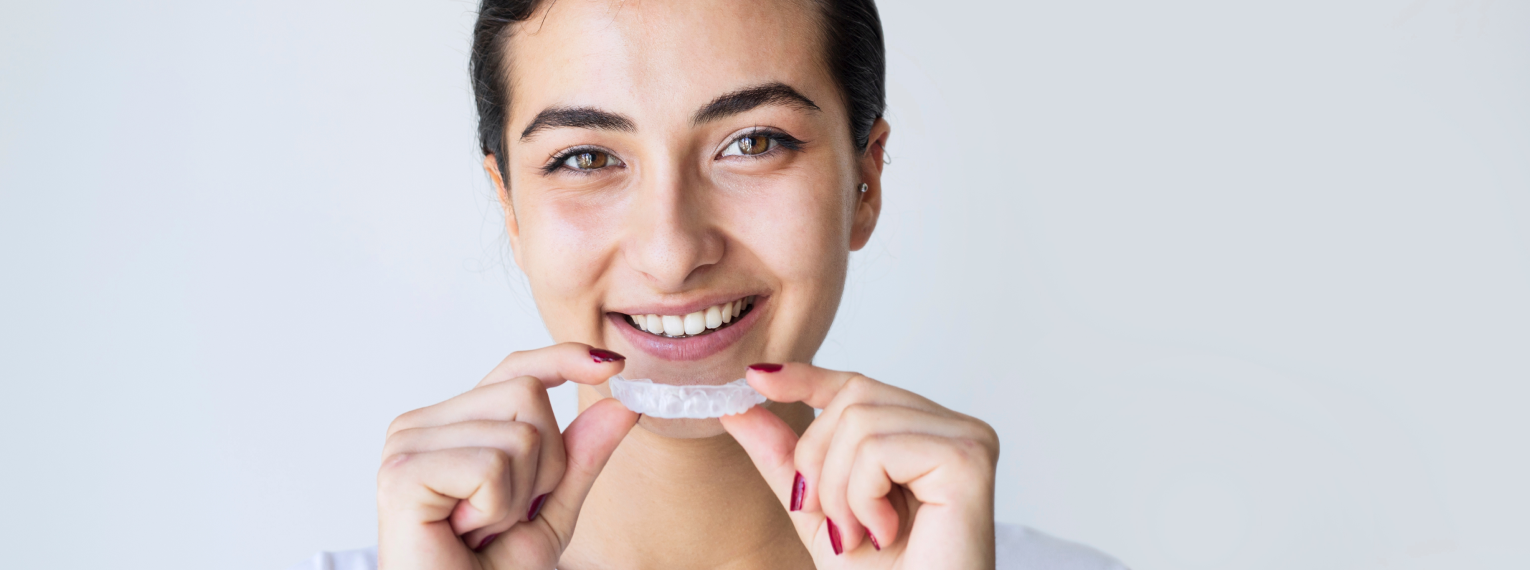 Eine Frau zieht eine Zahnschiene an.