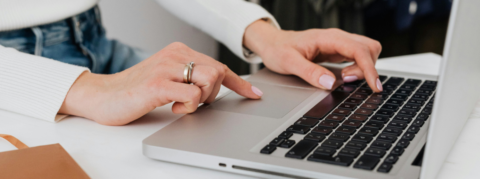 Eine Person füllt am Laptop einen Vertrag für eine Zahnzusatzversicherung aus.