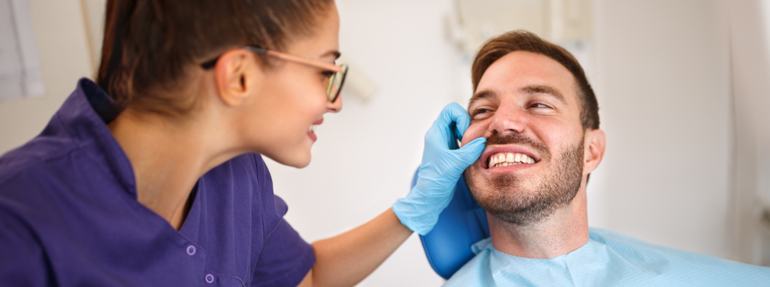 Ein Patient lächelt seine Zahnärztin an.