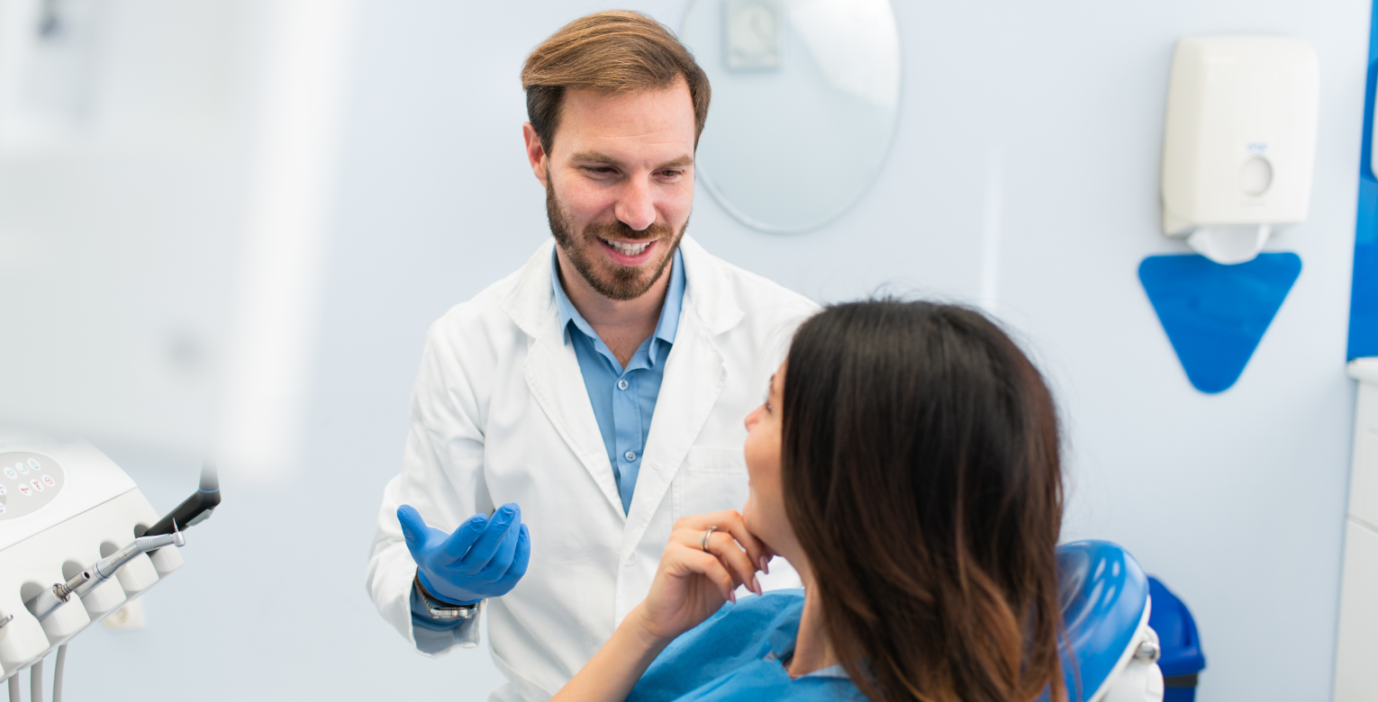 Ein Zahnarzt spricht mit einer Patientin.